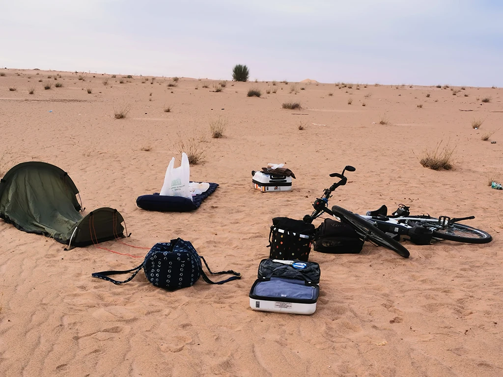 Zelt, Koffer und Fahhrad in der Wüste