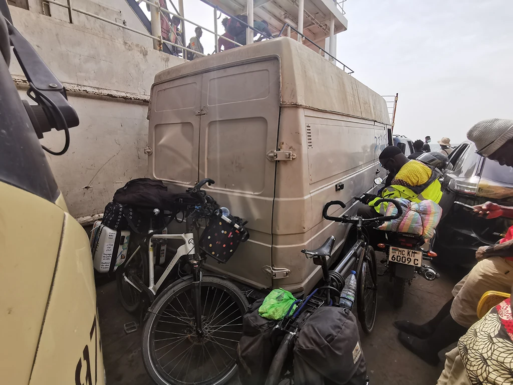 Dicht an Dicht stehen Fahrräder und Autos auf der Fähre über das Gambia Delta.