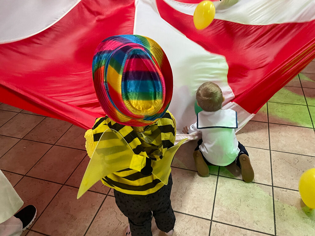 Ein kleiner Junge als Biene verkleidet mit einer bunt schimmernden Maske.