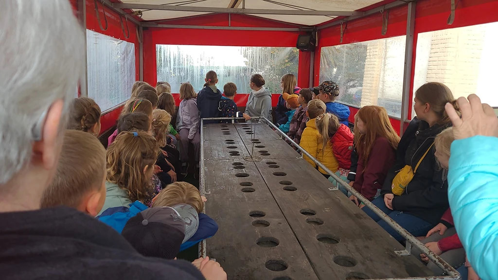 Kinder um einen Tisch im Planwagen