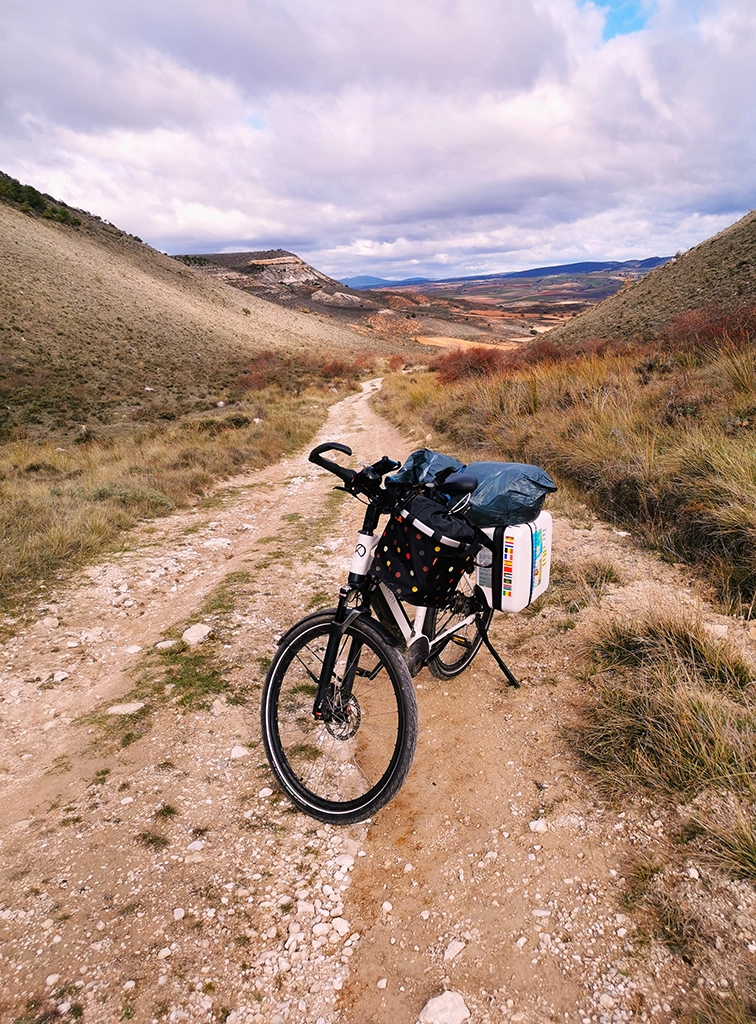 Das Fahrrad steht im Gebirge auf einer Piste mit Schotter und Sand